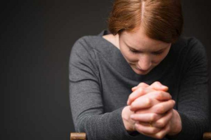 woman praying during prelude
