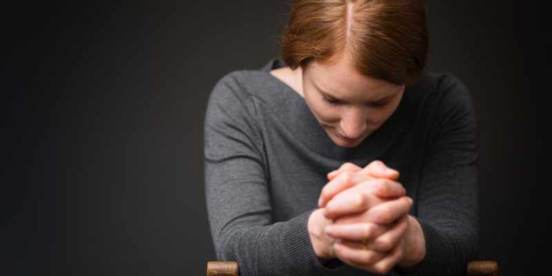woman praying during prelude